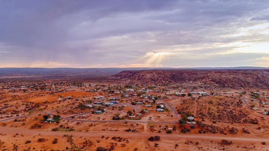 A cross stands on a hill above Santa Teresa as the sun rises.