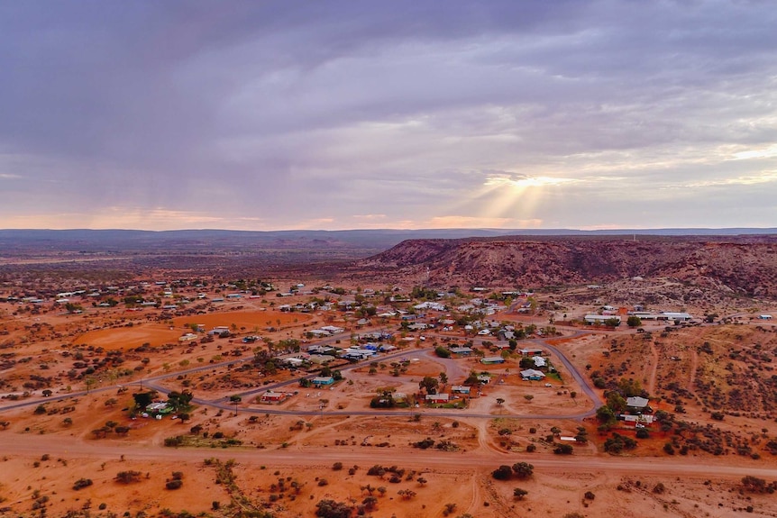 A cross stands on a hill above Santa Teresa as the sun rises.