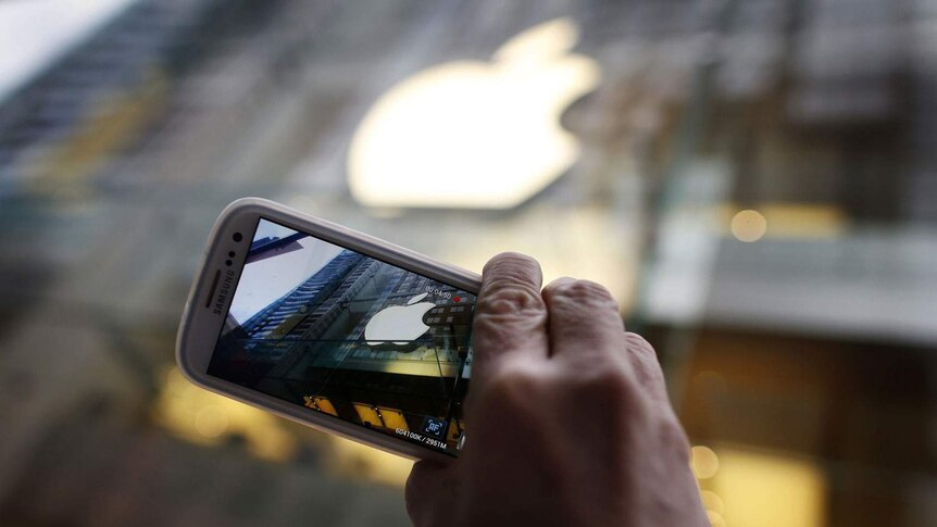 Passerby photographs Apple store logo with his Samsung Galaxy phone