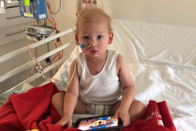 Marko on a hospital bed, with a tube up his nose, during his neuroblastoma treatment.