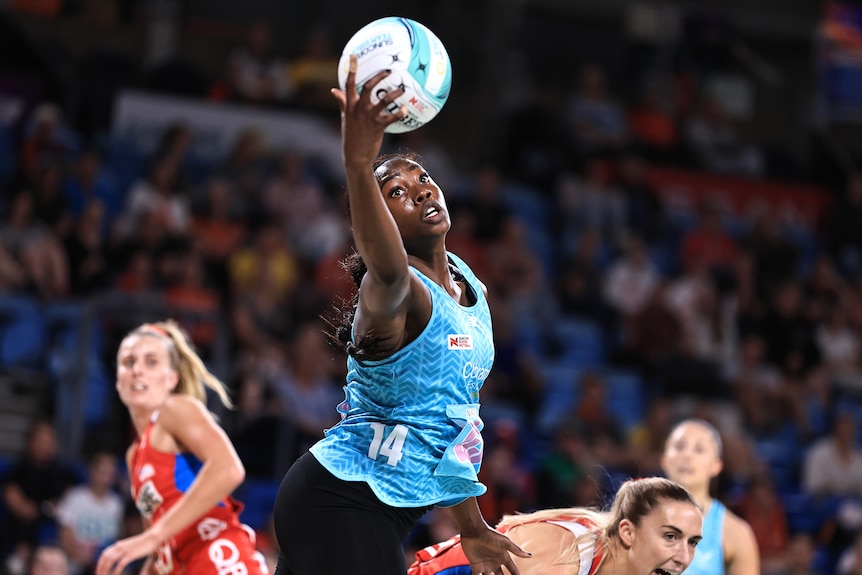 Shimona Jok reaches for the ball in a blue Mavericks outfit.