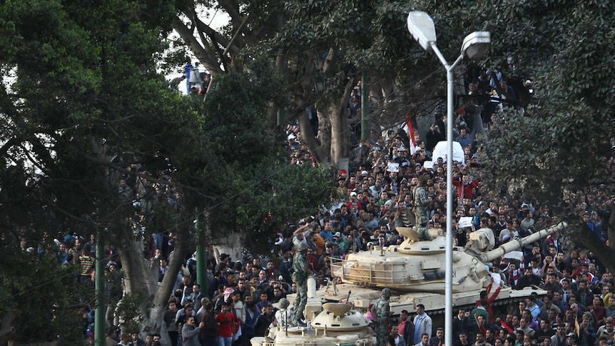 Egyptian demonstrators demanding the ouster of President Hosni Mubarak gather around army tanks in Cairo.