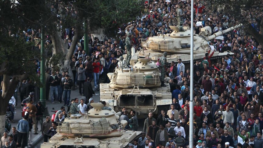 Egyptian demonstrators gather around army tanks in Cairo (AFP: Khaled Desouki)