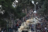 Egyptian demonstrators demanding the ouster of President Hosni Mubarak gather around army tanks in Cairo.