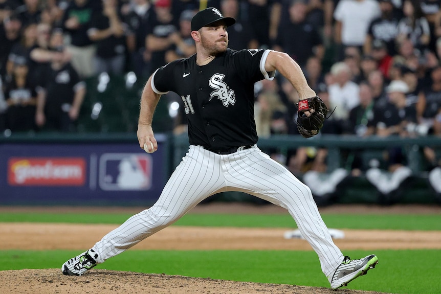 A Chicago White Sox pitcher prepares to throw a ball with his right hand during an MLB game.