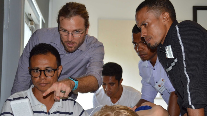 Australian doctor Joshua Francis assists Timor-Leste health workers.