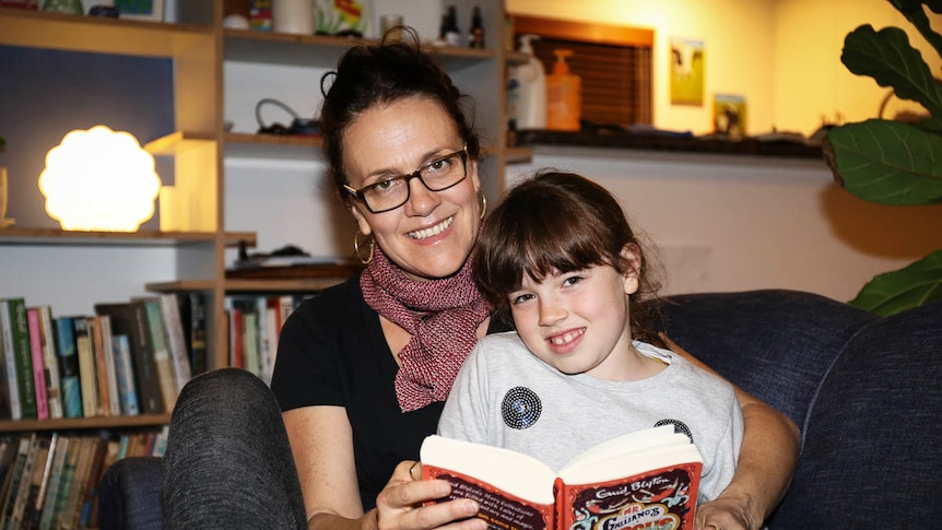 Sarah Armstrong and Amelia sitting together reading a book. Another option for parents concerned about screentime