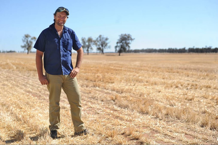 El presidente de la Federación de Agricultores de Victoria, David Jochinke, de pie frente a un prado cosechado.