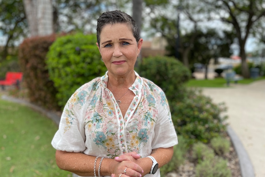 Lady stands with hands clenched and stoic expression