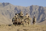 Australian soldiers stand in a field in Afghanistan