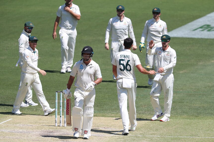 Colin de Grandhomme walks off as Australian players group together behind him