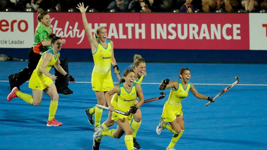 Australian players eun onto the pitch with their arms raised in joy.
