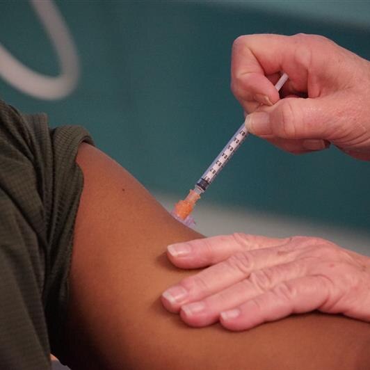 A vaccine is injected into an arm.