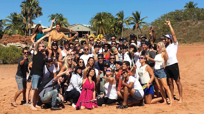 Image of a group of people posing for a photograph on a beach in Broome.