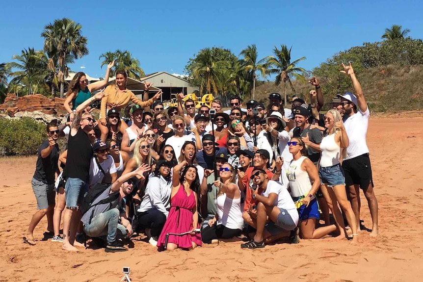 Image of a group of people posing for a photograph on a beach in Broome.