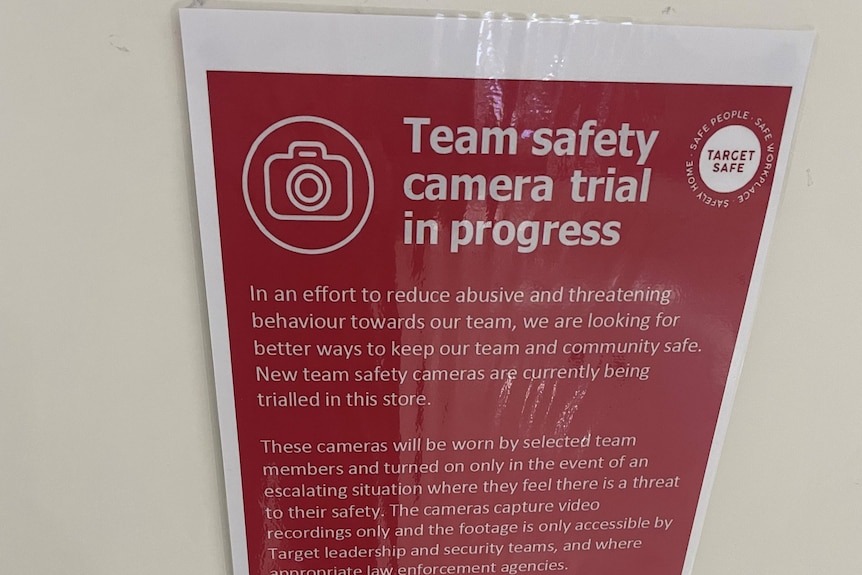 An image showing a red sign on a white wall explaining the decision for staff to trial wearing body cameras