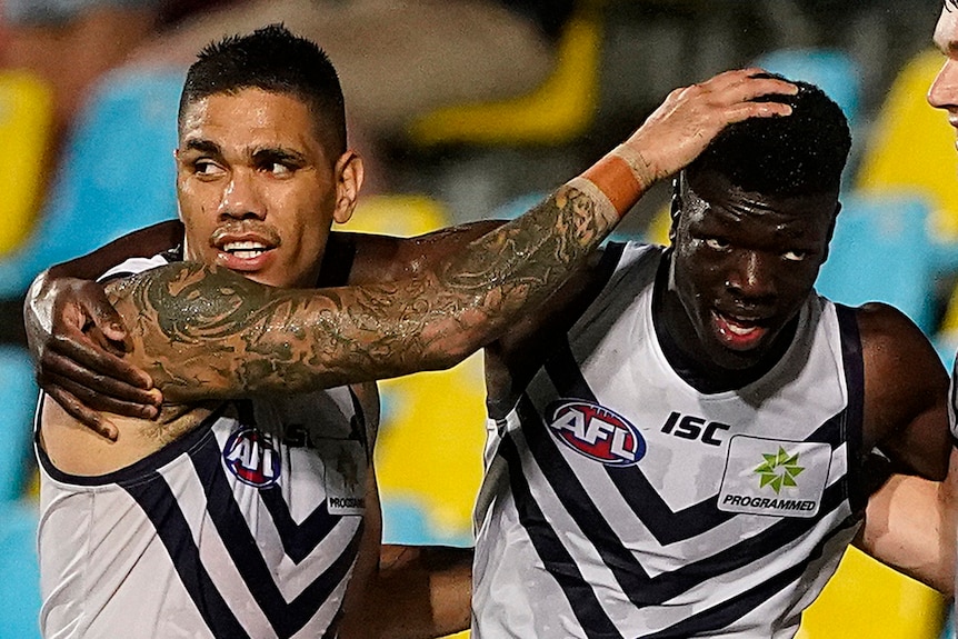 A close-up shot of Fremantle Dockers players Michael Walters and Michael Frederick celebrating after a goal.
