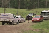 Police officer stands between police vehicles and other cars parked. January 1, 2017.