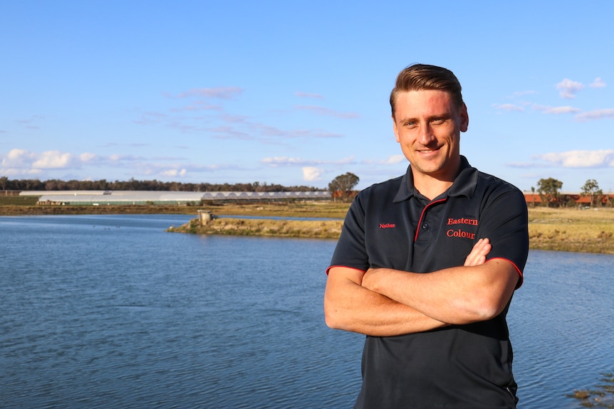 Applethorpe fruit grower Nathan Baronia standing next to an irrigation dam on his property, September 2020.