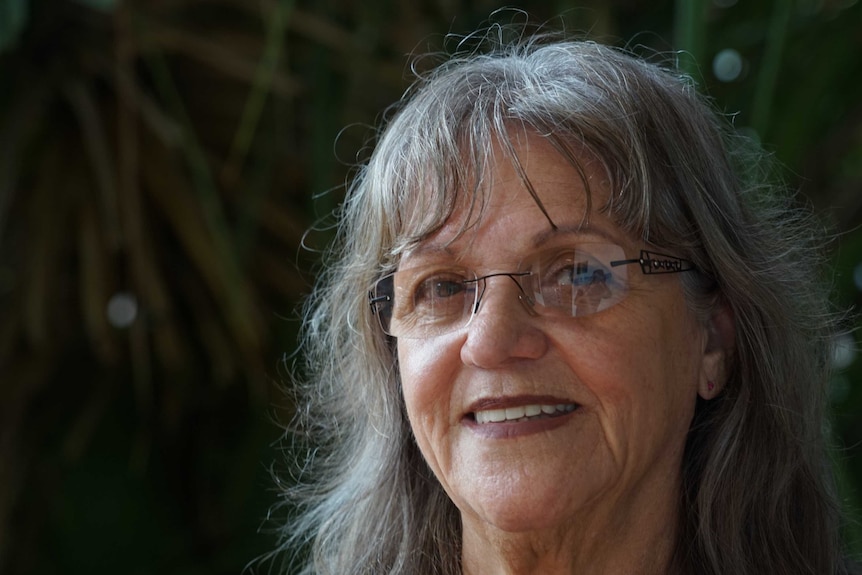 A close-up portrait of Colleen Rosas, who is smiling and wearing glasses.