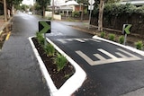 Two road signs have been painted over in a dark green colour.