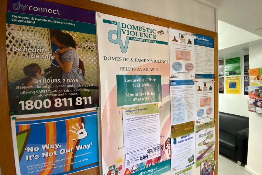 A noticeboard at a domestic violence support centre with posters and helplines. 