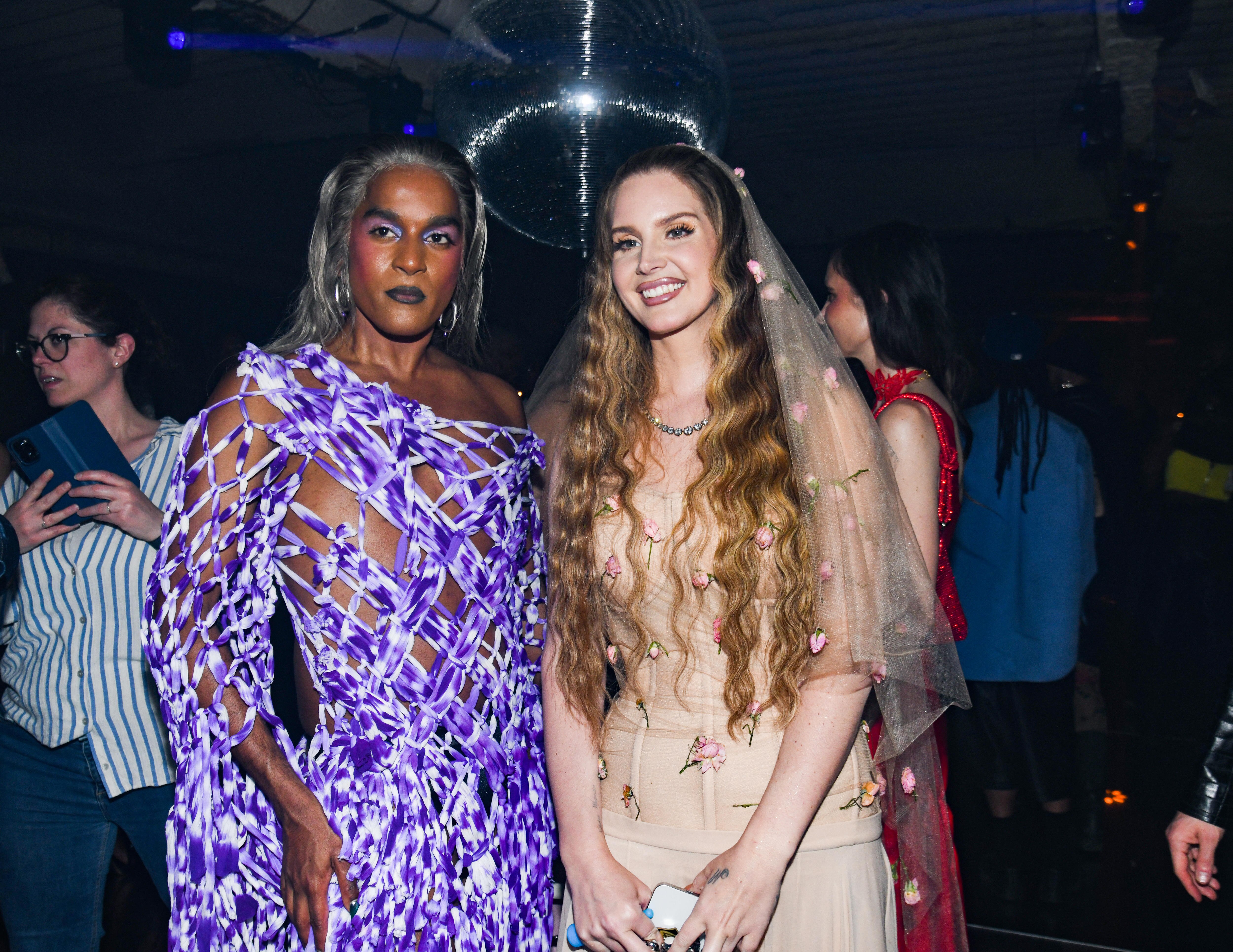A person in a net dress and a person in a dress with a veil.
