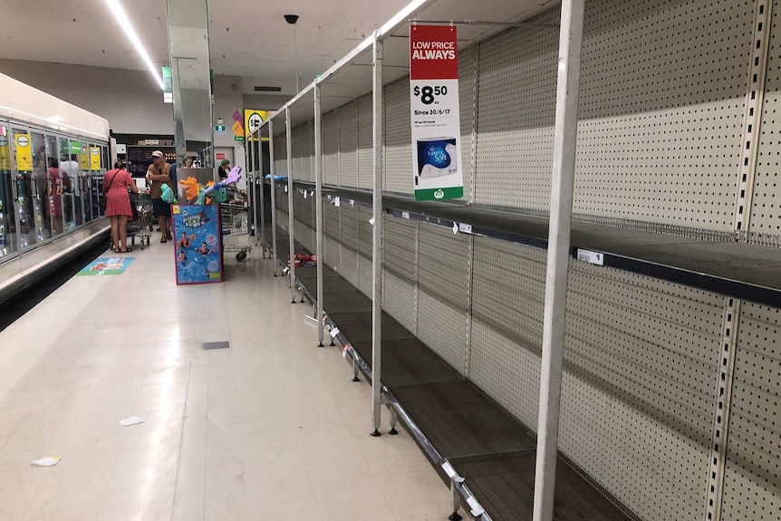 Empty supermarket shelves in a Woolworths store after they were cleared of toilet paper.