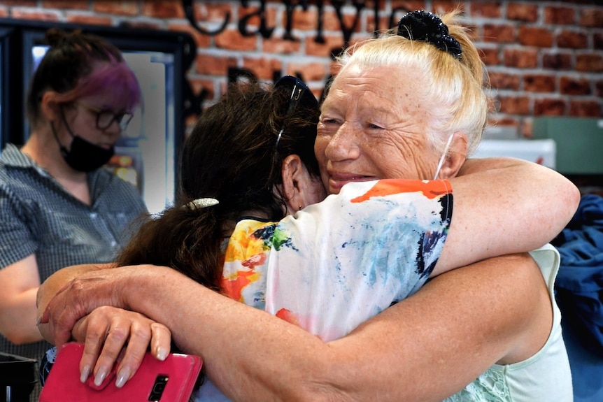 two women embracing in an airport