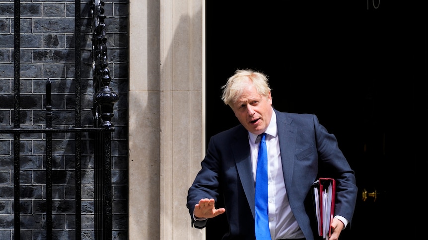 Boris Johnson gestures to journalists and photographers as he leaves 10 Downing Street