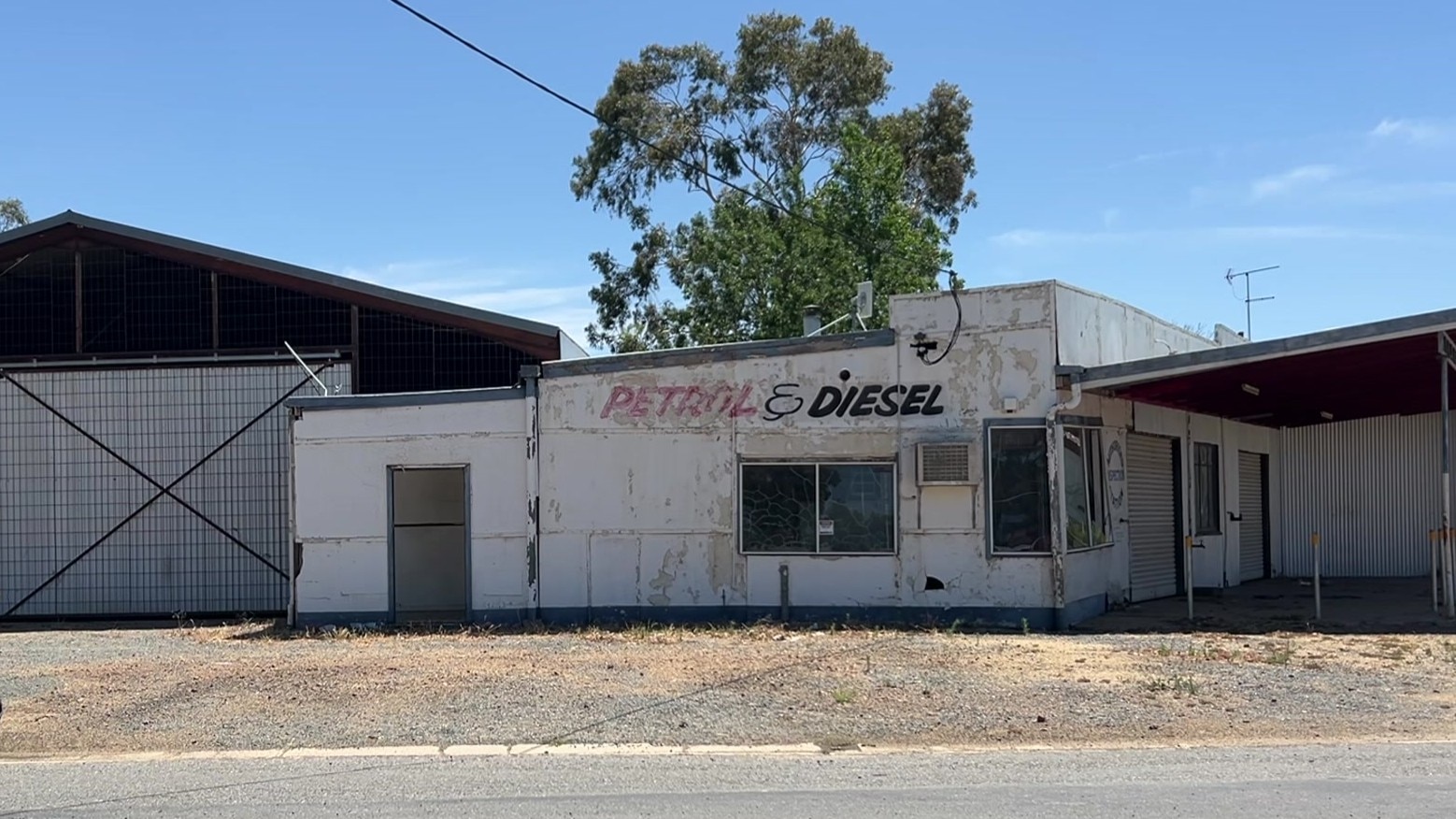 Uma loja fechada numa cidade do interior, gasolina e gasóleo pintados na parede. 