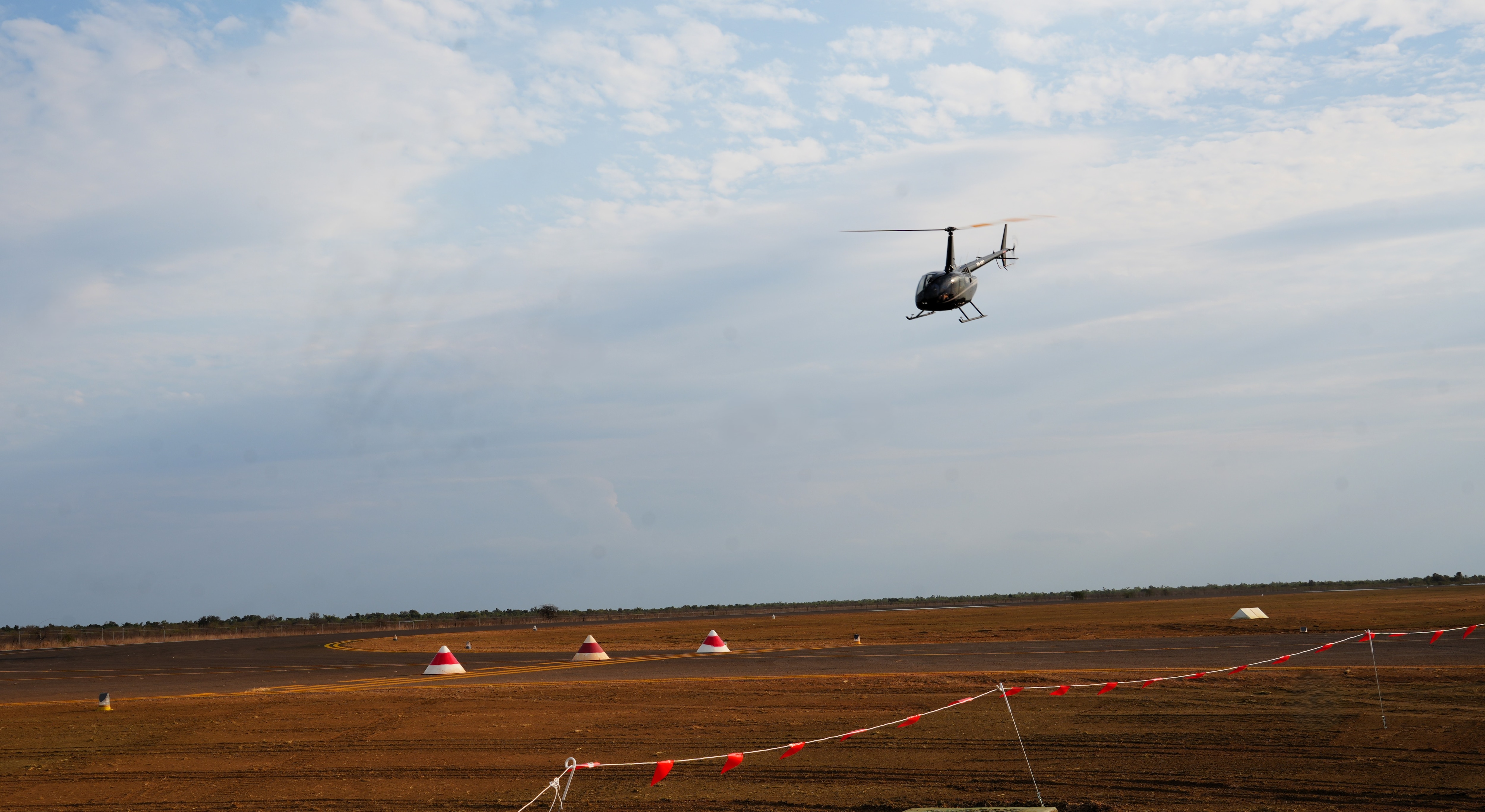 a black helicopter taking off on burketown's new airstrip