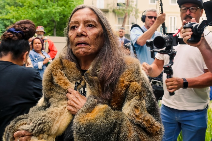 A woman wearing a possum skin cloak.