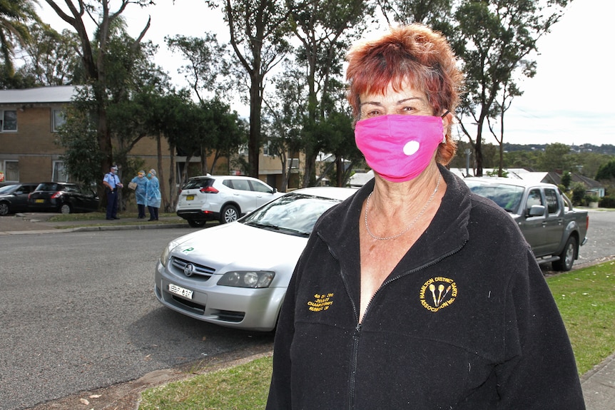 A female resident of James Street, Windale, wearing a mask pictured outside a block of units