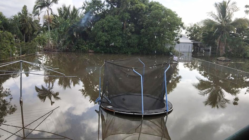 Flooded backyard with trampoline at property at Mill Road at Macknade in north Queensland