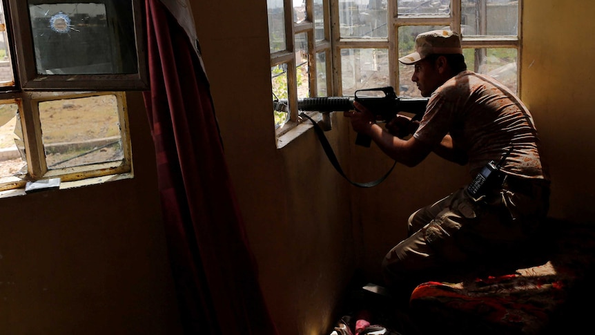 An Iraqi fighter take up position against Islamic State in Mosul.