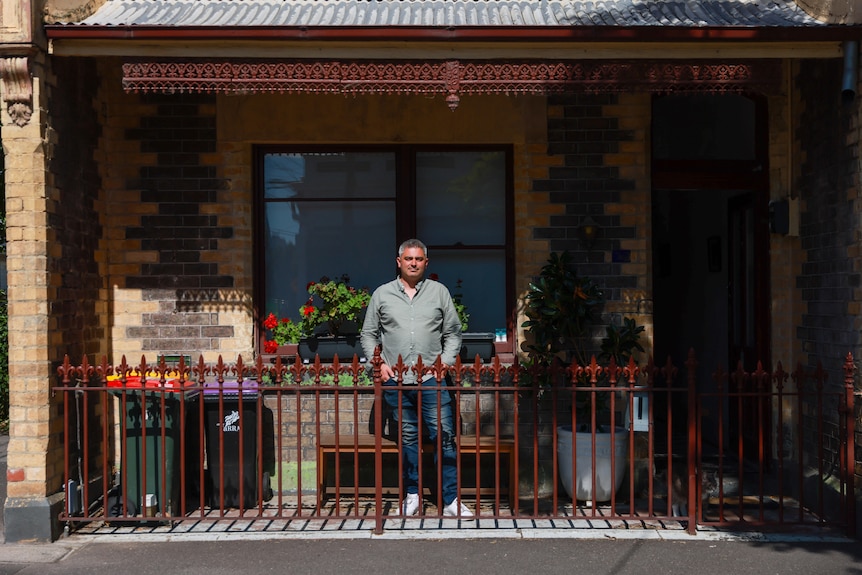 A man standing in the front of a terrace house