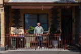 A man standing in the front of a terrace house