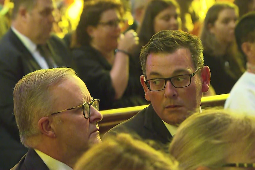 Daniel Andrews and Anthony Albanese seated at pews in a church