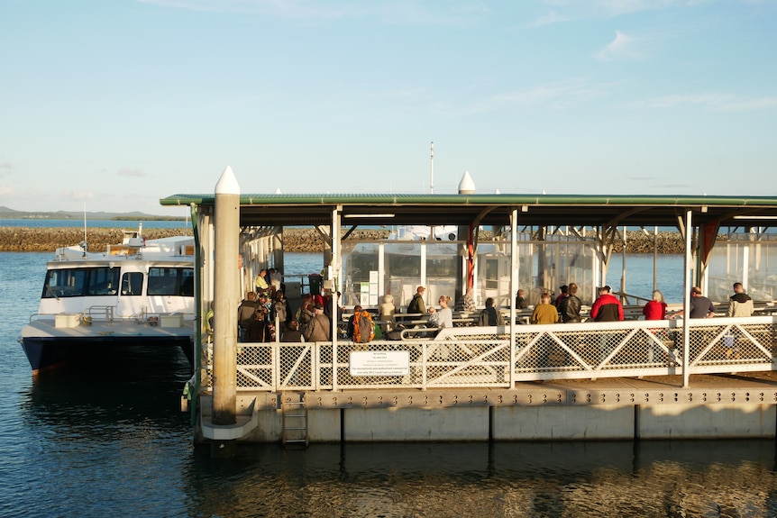 People line up to get on a ferry. 