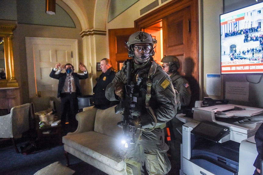 Capitol Police Swat team check everyone in the room as they secure the floor of Trump supporters