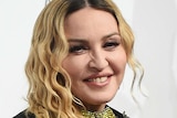 Head and shoulders shot of Madonna smiling for photographers