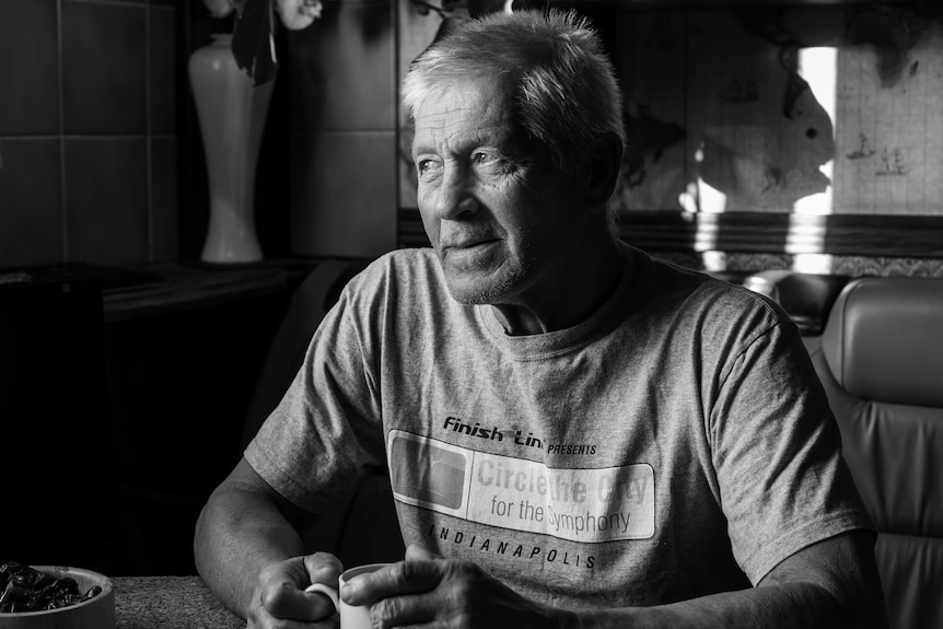 Black and white photo of Mikhail Farafanov in his eighties in a cafe.