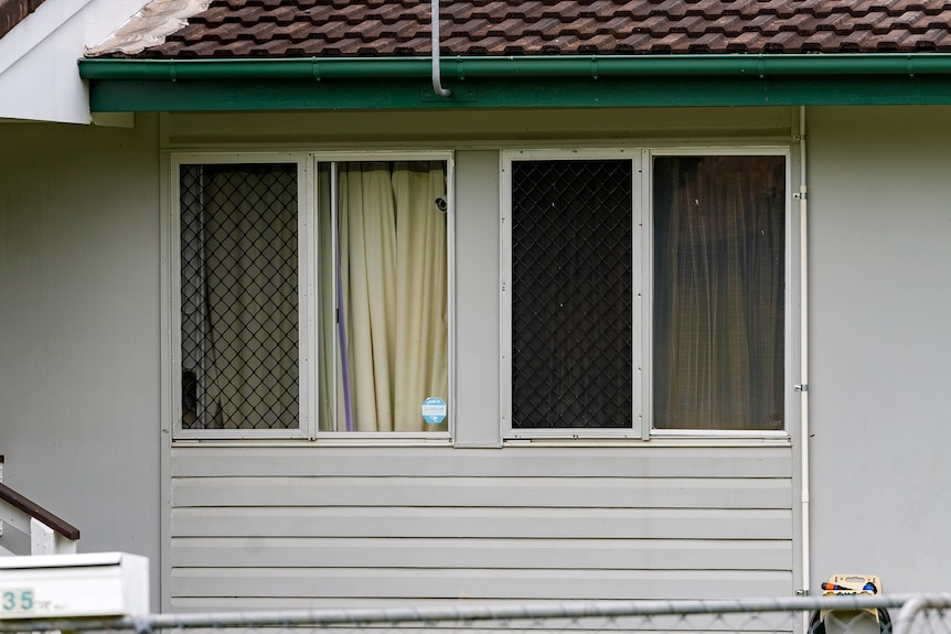 Exterior of windows of a weatherboard house.