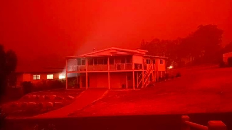 A vivid, red hue colours the entire view of a home in Mallacoota.