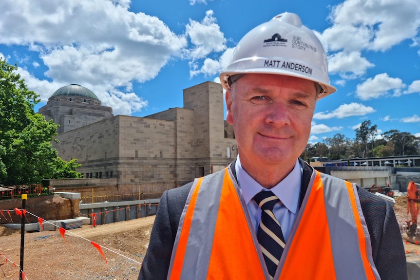 A man in a hard hat smiles.