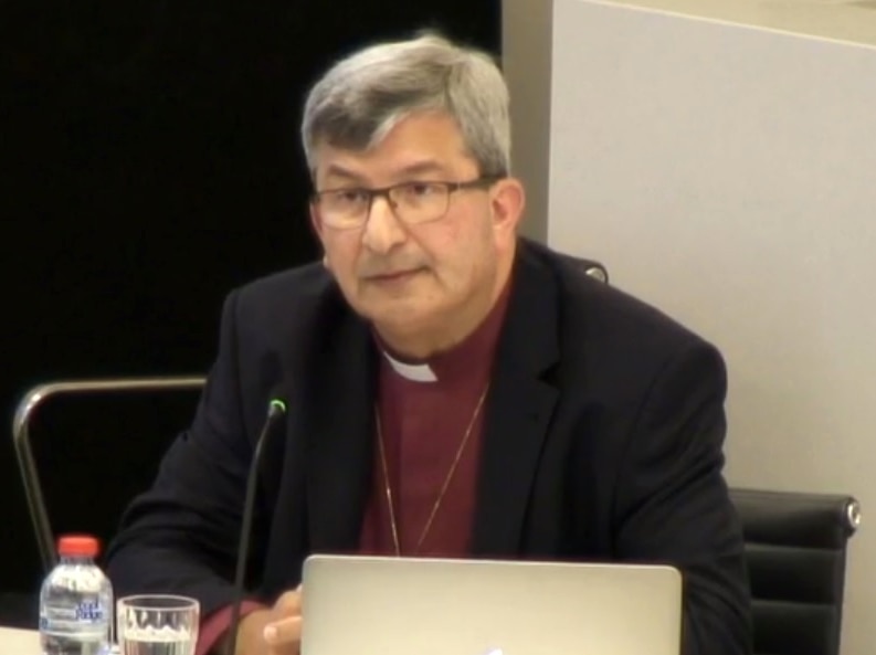 Perth's Archbishop Roger Herft sits and a desk giving evidence at the child sexual abuse royal commission.