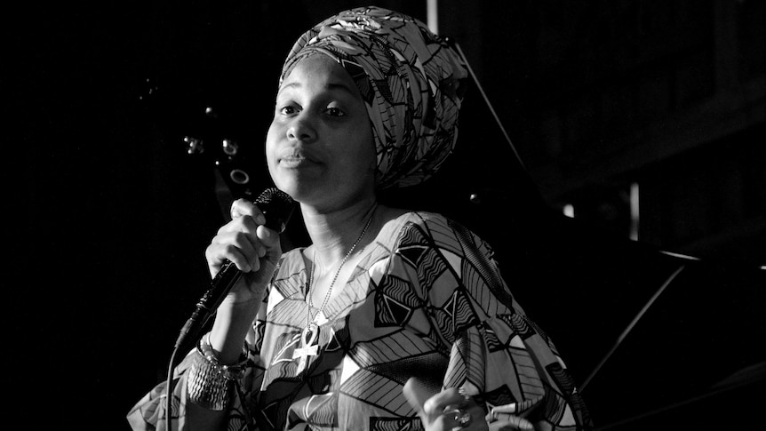 A monochrome photo of Jazzmeia Horn singing into a mic