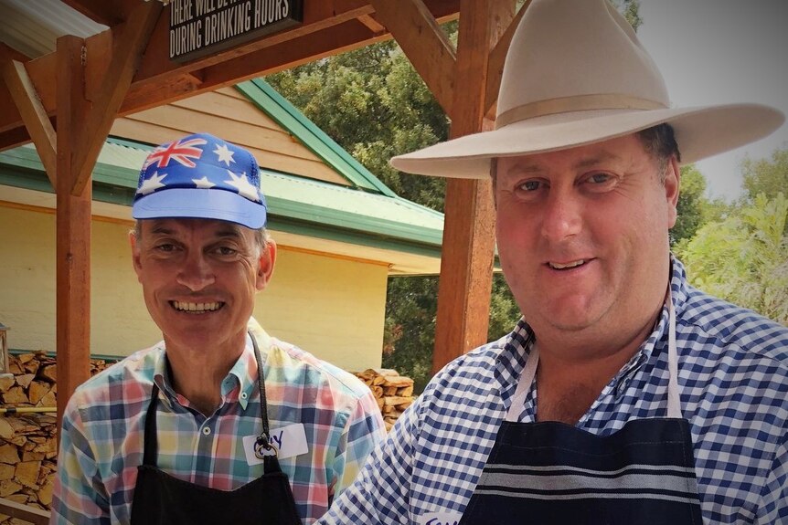 Two men wearing hats at a barbecue.