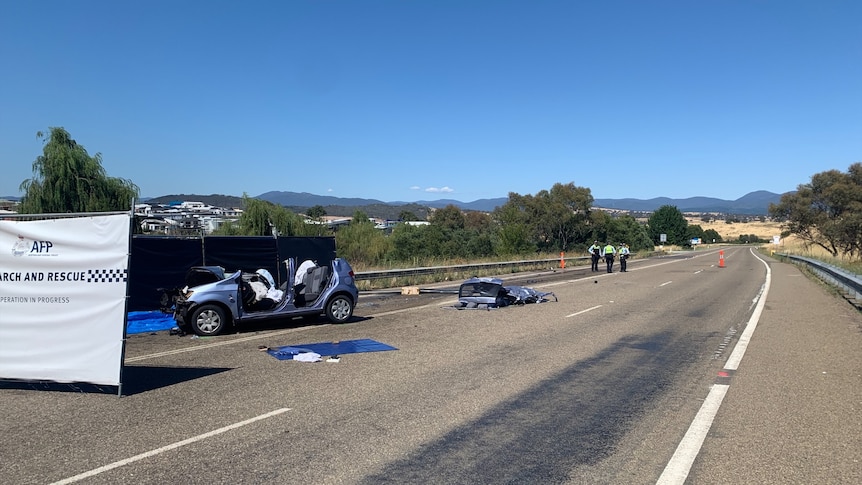 A smashed up hatchback car, with ACT police temporary fences set up nearby.